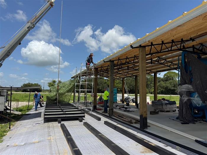 The treatment building under construction, roof going on with a crane on site.